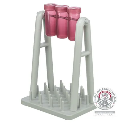 Juguete con tres recipientes rosas en una estructura gris y una base con clavijas. Certificado de bienestar animal visible: Animal Welfare Compliant, número de inspección 201711041.