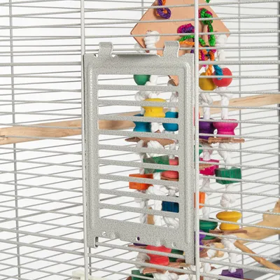 Vogelkooi met metalen tralies en kleurrijk houten speelgoed, bevestigd aan witte touwen. Geschikt voor vogels om bezig te zijn en te spelen.