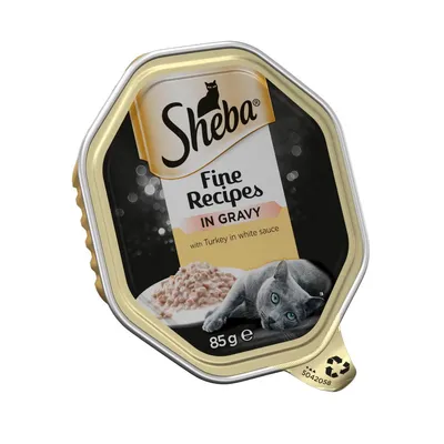 Sheba Fine Recipes in Gravy with turkey in white sauce, 85g tray shown. Product packaging displays food and recycling symbol. Sheba Fine Recipes in Gravy with turkey in white sauce, 85g tray shown. Product packaging displays food and recycling symbol.