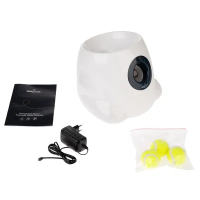 Nomad Tales Bloom automatische tennisballwerper met handleiding, netadapter en drie gele tennisballen in tas.