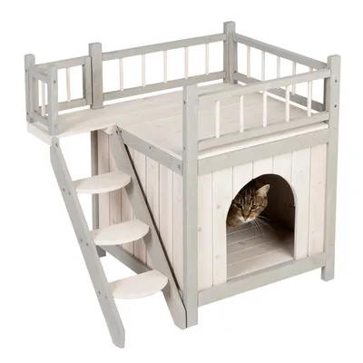 Casa para gatos de madera con escalera, balcón y zona interior protegida. Gato sentado en la parte inferior de la casa.