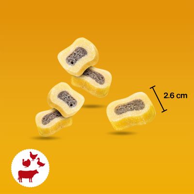 Przekąska z żółtą otoczką i ciemnym nadzieniem, długość 2,6 cm. Symbol wołowiny, kurczaka, kaczki i indyka w lewym dolnym rogu.