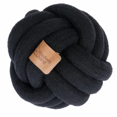 Zwarte knoop-speelbal van stof met bruin leren label, opschrift 'Modern Living'.