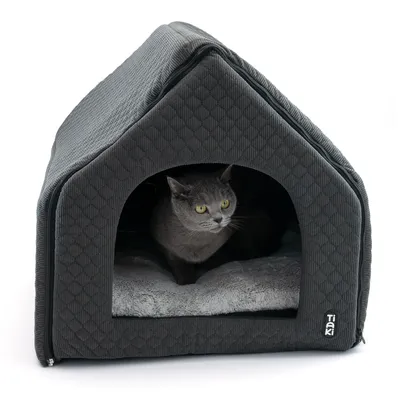 Grey cat house with soft inner padding, cat sitting inside. 'Taki' brand logo visible bottom right.
