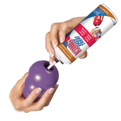 KONG Easy Treat pindakaassmaak wordt in een paars KONG-speelgoed gevuld. Instructie voor vullen zichtbaar.