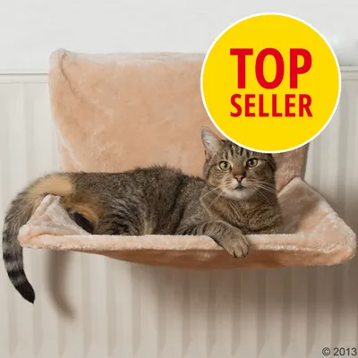 Katt ligger på beige hängsäng av tyg monterad på element. Gul cirkel med röd text: TOP SELLER delvis över kattens huvud.