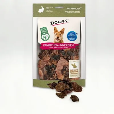 DOKAS Kaninchen-Innereien hondensnack, zichtbare stukjes long, maag, lever en hart in transparante verpakking. Tekst: 100% kaninchen, das wertte kaninchen, animal welfare guarantee.