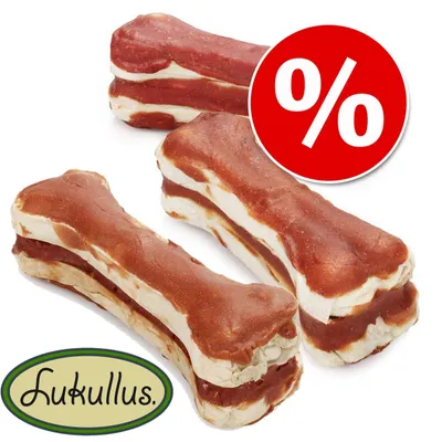 Lukullus os à mâcher avec design en couches rouges et blanches. Symbole pourcentage rouge sur cercle blanc pour promotion.