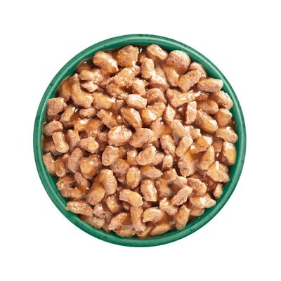 Chunks of wet pet food in gravy served in a green bowl, shown from above to display texture and portion size.