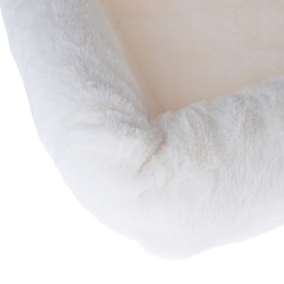 Close-up van wit, pluizig materiaal, mogelijk onderdeel van een huisdierenbed of deken.