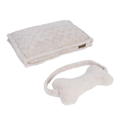 Beige hondenspeelgoed in botvorm met handvat en bijpassend kussen van zachte stof.