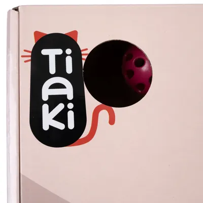 Box with a circular hole showing a pink ball inside and the word 'Tiaki' in bold letters on the side.
