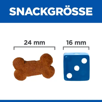 Comparaison de taille : friandise en forme d’os 24 mm à côté d’un dé bleu 16 mm. Texte allemand « SNACKGRÖSSE » visible en haut de l’image.