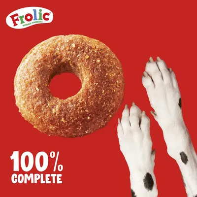 Frolic, 100% complete. Widoczny okrągły kawałek karmy oraz łapy psa na czerwonym tle. Tekst w języku angielskim.