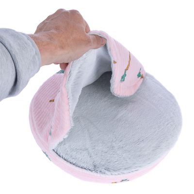 Hand öffnet eine rosa und graue, weiche Tierhöhle mit Karottenmuster. Zeigt die Innenseite aus Plüschmaterial.