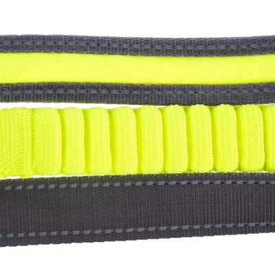 Gros plan sur une laisse en nylon jaune fluo et gris, avec section élastique visible au centre. Coutures renforcées apparentes.