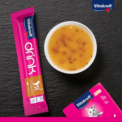 Vitakraft Drink med L-karnitin, smak av kyckling. Förpackning och serverad vätska synliga. Utan tillsatt socker, utan mjölk. Made in Germany.