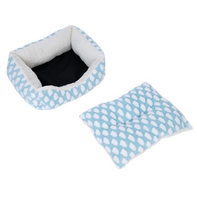 Letto per pet azzurro con motivo a nuvole bianche e cuscino estraibile. Fodera interna in materiale morbido, fondo nero visibile.