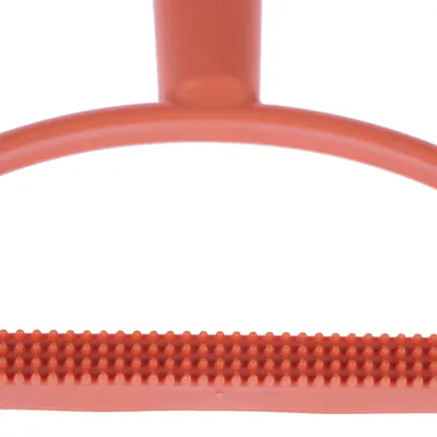 Närbild av ett orangefärgat borsthuvud i plast med noppor, lämpligt för pälsvård.