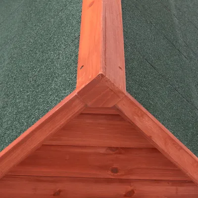 Detailný pohľad na drevený strešný štít so zelenou, vodoodpudivou strešnou krytinou.