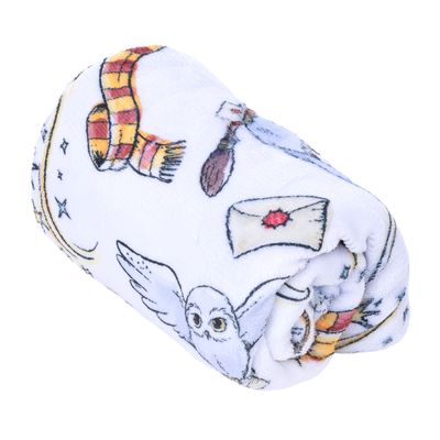 Vit filt med Harry-Potter-motiv: uggla, kvast, brev med rött sigill, halsduk och stjärnor.