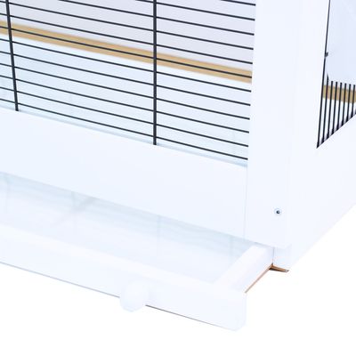 Detaljvy av en vit bur med utdragbar plastlåda och svarta gallerstänger.