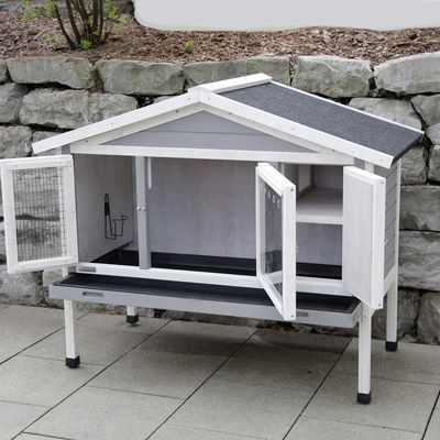 Biely domček pre malé zvieratá s dvomi dverami, mrežovaným oknom a čiernou strechou. Vnútorný priestor s poličkou a držiakom na príslušenstvo. Vhodné na vonkajšie použitie.