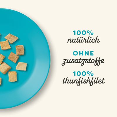 100% natürlich, ohne Zusatzstoffe, 100% Thunfischfilet. Produktabbildung mit getrockneten Thunfischstücken auf einem blauen Teller.