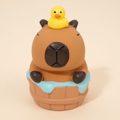 Jouet en caoutchouc en forme d’animal brun avec un canard de bain jaune sur la tête, assis dans un tonneau orné de motifs bleus.