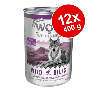 Wolf of Wilderness Senior Wild Hills våtfoder, 100% grain-free, 12x400 g. Text: Anka & kalv med skogsbär, rötter och vilda örter. Bild på varg och bergslandskap.
