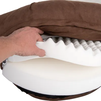 Hand showing layers of a brown pet bed: removable cover, wavy and flat foam core.