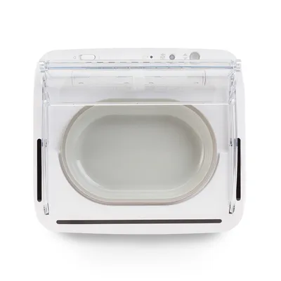 Automatski dozator hrane s bijelim kućištem i prozirnim poklopcem, prikazuje ovalnu posudu za hranu unutra.