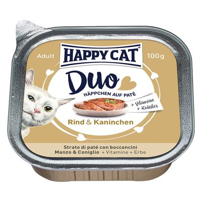 HAPPY CAT Duo Häppchen auf Paté, Rind & Kaninchen, 100 g. + Vitamine + Kräuter. Strato di paté con bocconcini Manzo & Coniglio. Billede af kat og skål med foder synlig.