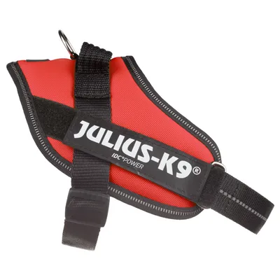 Hundesele med synlig tekst: JULIUS-K9 IDC® POWER. Selen har sorte stropper og metalring, rød overflade og sort kant.
