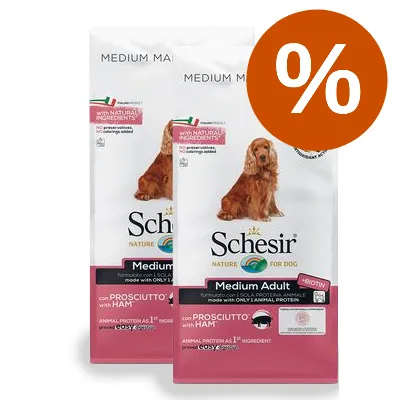 Två påsar Schesir Medium Adult hundfoder med skinka, synlig text: 'with natural ingredients', 'con prosciutto with ham', stor orange procent-symbol för rabatt. Två påsar Schesir Medium Adult hundfoder med skinka, synlig text: 'with natural ingredients', 'con prosciutto with ham', stor orange procent-symbol för rabatt.