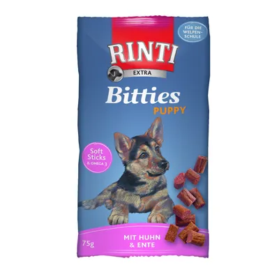 RINTI Extra Bitties Puppy - Soft Sticks & Omega 3, mit Huhn & Ente, 75 g. Kuvassa pentukoira ja koiranherkkupaloja. Tekstiä myös saksaksi.