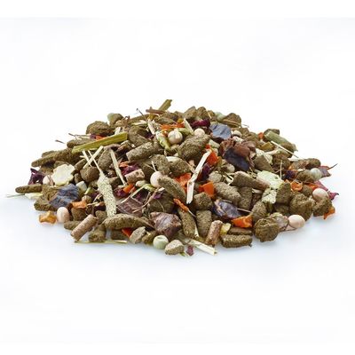 Mélange d’aliments pour petits animaux, composé de granulés, morceaux de légumes séchés et herbes visibles, présenté en vrac sur fond blanc.