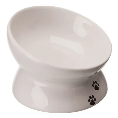 White ceramic bowl with raised base and black paw prints on the bottom.