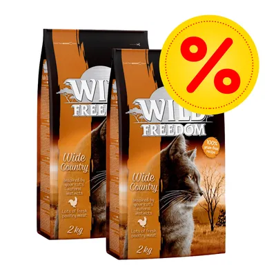 Kaksi Wild Freedom Wide Country -kuivaruokapussia kissoille, 2 kg. Pakkauksessa teksti: '100% grain-free recipe', 'Lots of fresh poultry meat'. Keltainen alennusmerkki (%) näkyvissä.