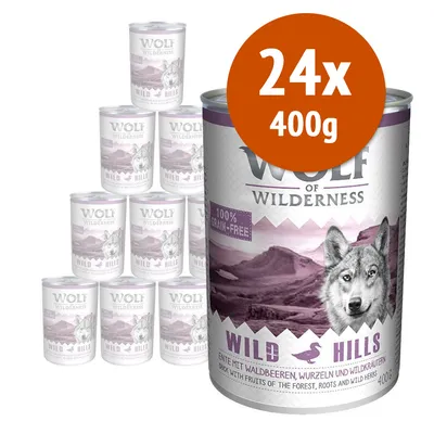 Wolf of Wilderness Wild Hills, confezione da 24 lattine da 400 g. Testo visibile: 100% grain-free. Gusto anatra con frutti di bosco, radici ed erbe selvatiche.