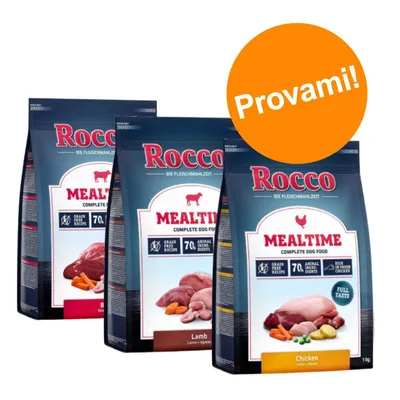 Tre confezioni di Rocco Mealtime Complete Dog Food: Beef, Lamb, Chicken. Testo visibile: 'Grain free recipe', '7% animal ingredients', bollino arancione con scritta 'Provami!'.