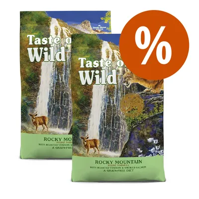 Due confezioni di Taste of the Wild Rocky Mountain Feline Formula, testo visibile: 'with roasted venison & smoked salmon, a grain-free diet', simbolo percentuale arancione in alto a destra. Due confezioni di Taste of the Wild Rocky Mountain Feline Formula, testo visibile: 'with roasted venison & smoked salmon, a grain-free diet', simbolo percentuale arancione in alto a destra.