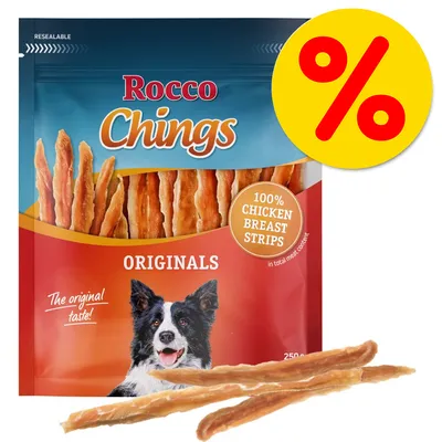 Rocco Chings Originals, 100% Chicken Breast Strips, 250 g. Tarjousmerkintä keltaisella taustalla. Pakkauksessa koiran kuva ja teksti 'The original taste!'.