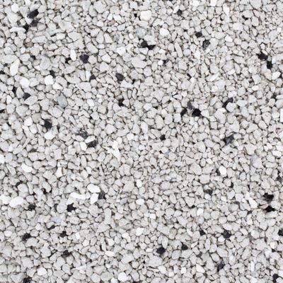 Close-up van grijze kattengrit met kleine zwarte en witte korrels, grove structuur zichtbaar.