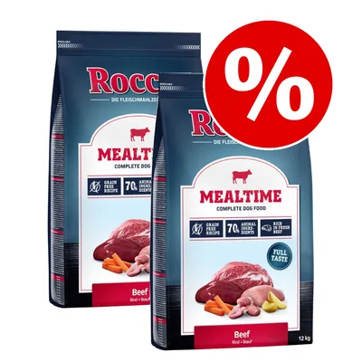To sække Rocco Mealtime Complete Dog Food Beef 12 kg med synlig tekst: Grain Free Recipe, 70% Animal Ingredients, Rich in Fresh Beef, Full Taste. Rødt procenttegn øverst til højre.