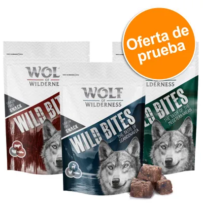 Wolf of Wilderness Wild Bites, snack sin cereales. Tres bolsas con diferentes variedades y trozos de snack delante. Círculo naranja con texto: Oferta de prueba.