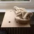 Wooden windowsill attachment with beige plush cover, suitable for pets. Two holes and metal clip visible.