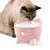 Katzentrinkbrunnen in Rosa mit fliessendem Wasser, katzenförmigem Design und einer Katze, die daraus trinkt.
