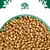 Bowl filled with dry pet food kibble, shown from above. Green bowl and tree-shaped emblem with animal silhouettes visible at the top.