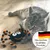 Katze spielt mit einem schwarz-orangefarbenen Stoffspielzeug in Spinnenform. Siegel: Deutsches Qualitäts-Produkt mit Deutschlandflagge.